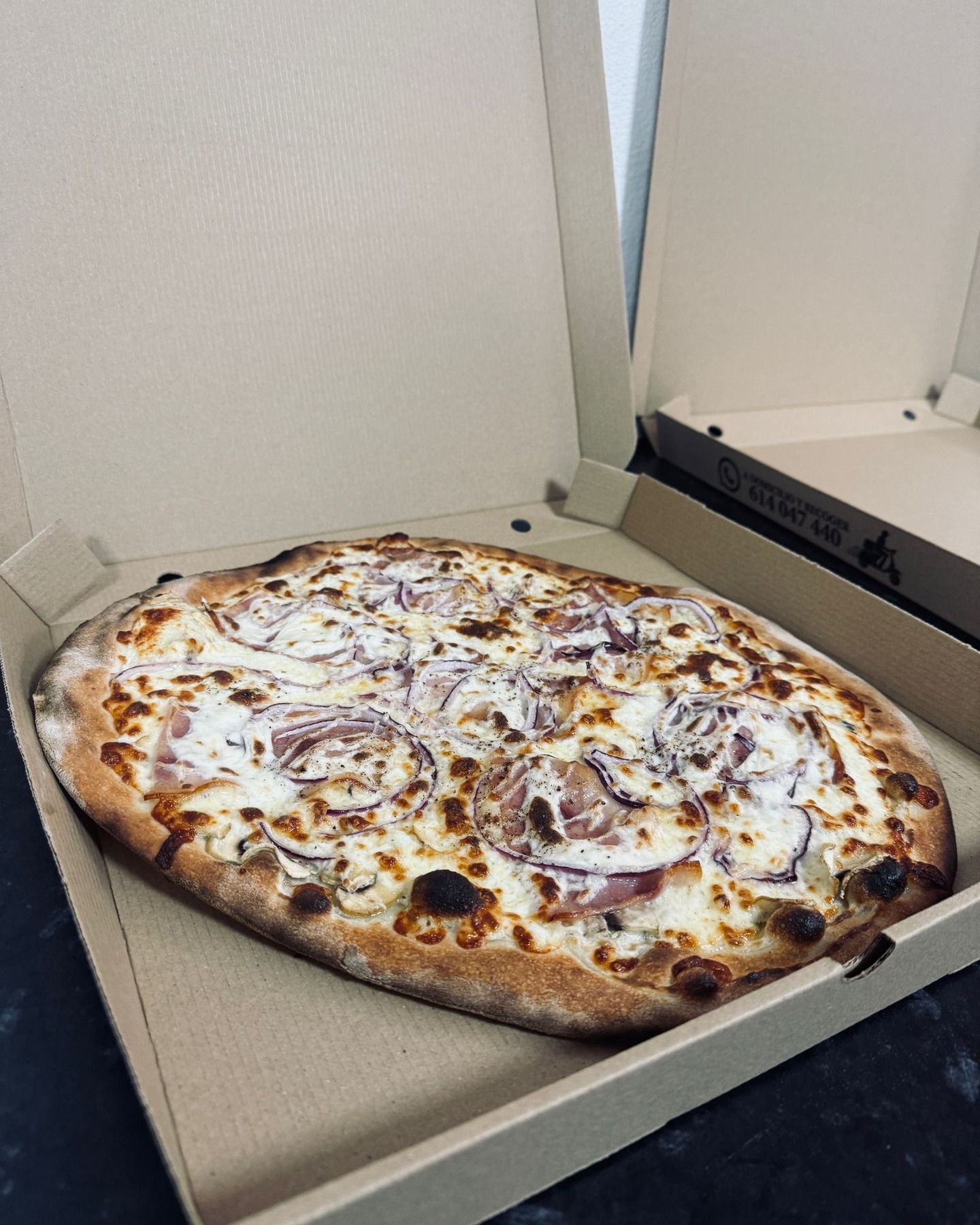 Pizza de Pizzería Bella recién preparada en su caja para llevar
